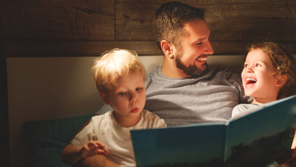 Papà che legge un libro ai figli